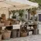 Étal de paniers et de céramiques sous un auvent sur une place de marché