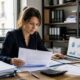 Dirigeante analysant des factures clients avant de recourir à l’affacturage