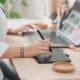 Graphiste utilisant un stylet et une tablette graphique devant son ordinateur portable