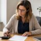Dirigeante calculant un escompte sur une facture professionnelle