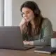 Femme portant un casque devant un ordinateur portable à domicile