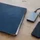 Dossier bleu, disque de sauvegarde et téléphone posé face contre une table.