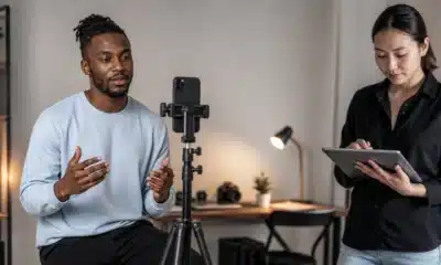 Créatrice filmant une courte vidéo verticale avec un smartphone dans un studio sobre