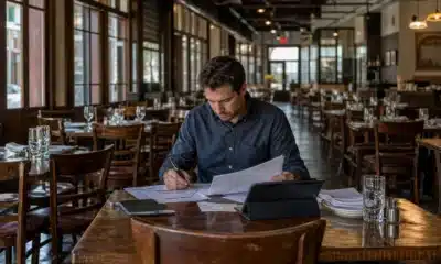 Gérante de restaurant analysant ses ventes et son organisation dans une salle vide