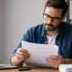 Freelance informatique relisant attentivement un contrat de mission avant signature