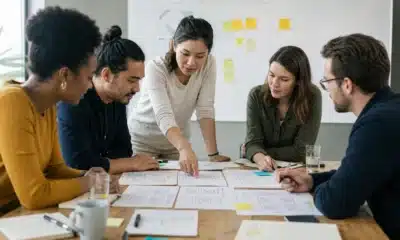 Équipe pluridisciplinaire comparant des maquettes pendant un atelier Design Sprint