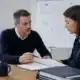 Franchiseur présentant le manuel opératoire et le plan de formation à une franchisée