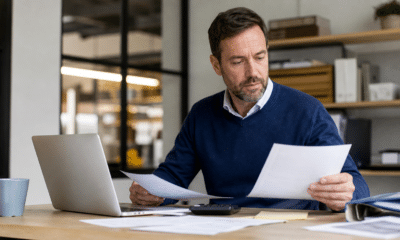 Dirigeant de PME analysant les coûts et factures de son entreprise