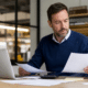 Dirigeant de PME analysant les coûts et factures de son entreprise