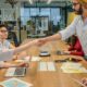 Deux professionnels se serrent la main autour d’une table de réunion.