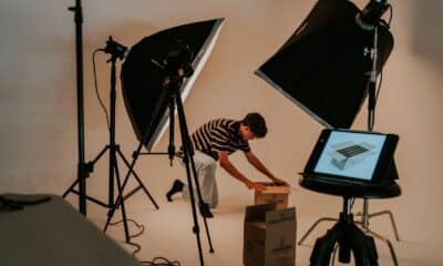 Un créateur prépare un déballage de produit entre deux éclairages de studio.