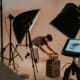 Un créateur prépare un déballage de produit entre deux éclairages de studio.