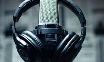 Casque audio posé autour d’un microphone de studio.
