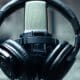 Casque audio posé autour d’un microphone de studio.