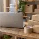 Ordinateur portable et colis en carton sur un bureau de préparation de commandes