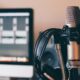 Microphone de studio et casque devant un écran de montage sonore