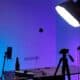Table de studio, trépied et éclairage bleu-violet pour préparer une prise de vue produit