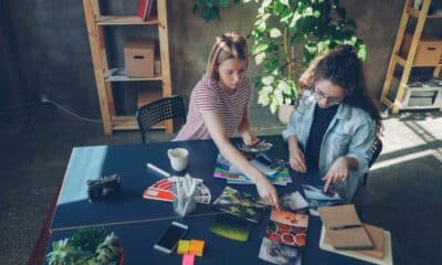 Deux professionnelles comparent des photographies et des nuanciers sur une table de studio