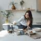 Une créatrice filme une vidéo dans sa cuisine avec un smartphone posé sur un trépied.