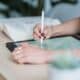 Designer dessinant au stylet sur une tablette posée sur un bureau en bois