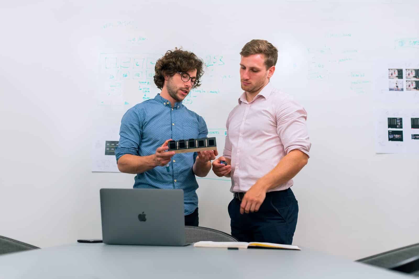 Deux ingénieurs examinent ensemble un prototype dans un bureau