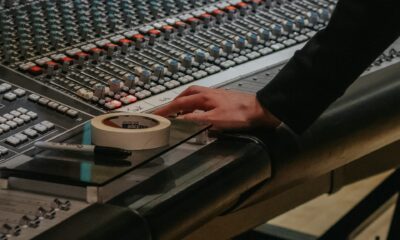 Une main règle une console de mixage audio en studio