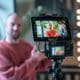 Présentateur filmé par une caméra avec écran de contrôle sur trépied