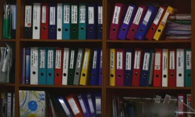 Classeurs colorés rangés sur des étagères en bois dans un bureau
