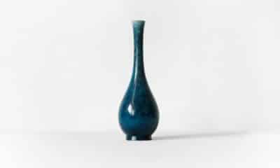 Vase en céramique bleue sur fond blanc, photographié de face