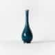 Vase en céramique bleue sur fond blanc, photographié de face