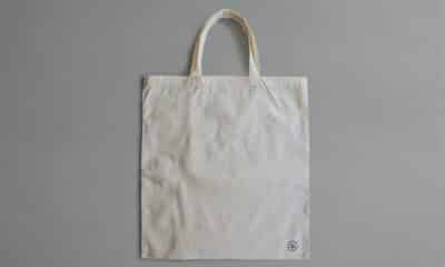 Sac en toile claire photographié de face sur un fond gris